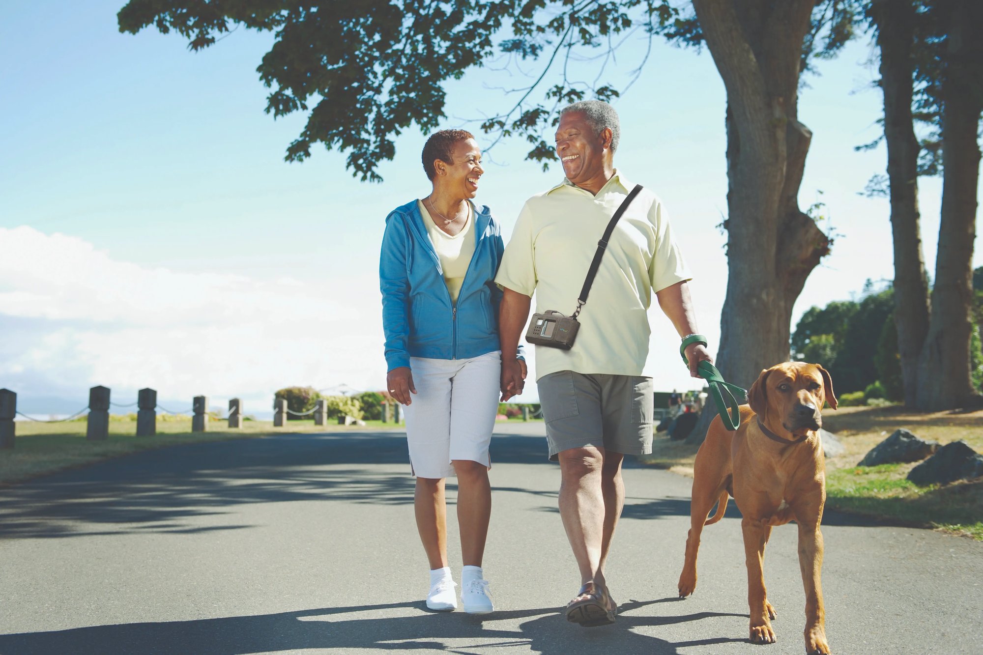 LifeVest wearable cardioverter defibrillator patient and spouse go on a walk with their dog in a park