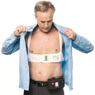 LifeVest wearable cardioverter defibrillator patient with shirt open showing the LifeVest garment worn directly against the skin