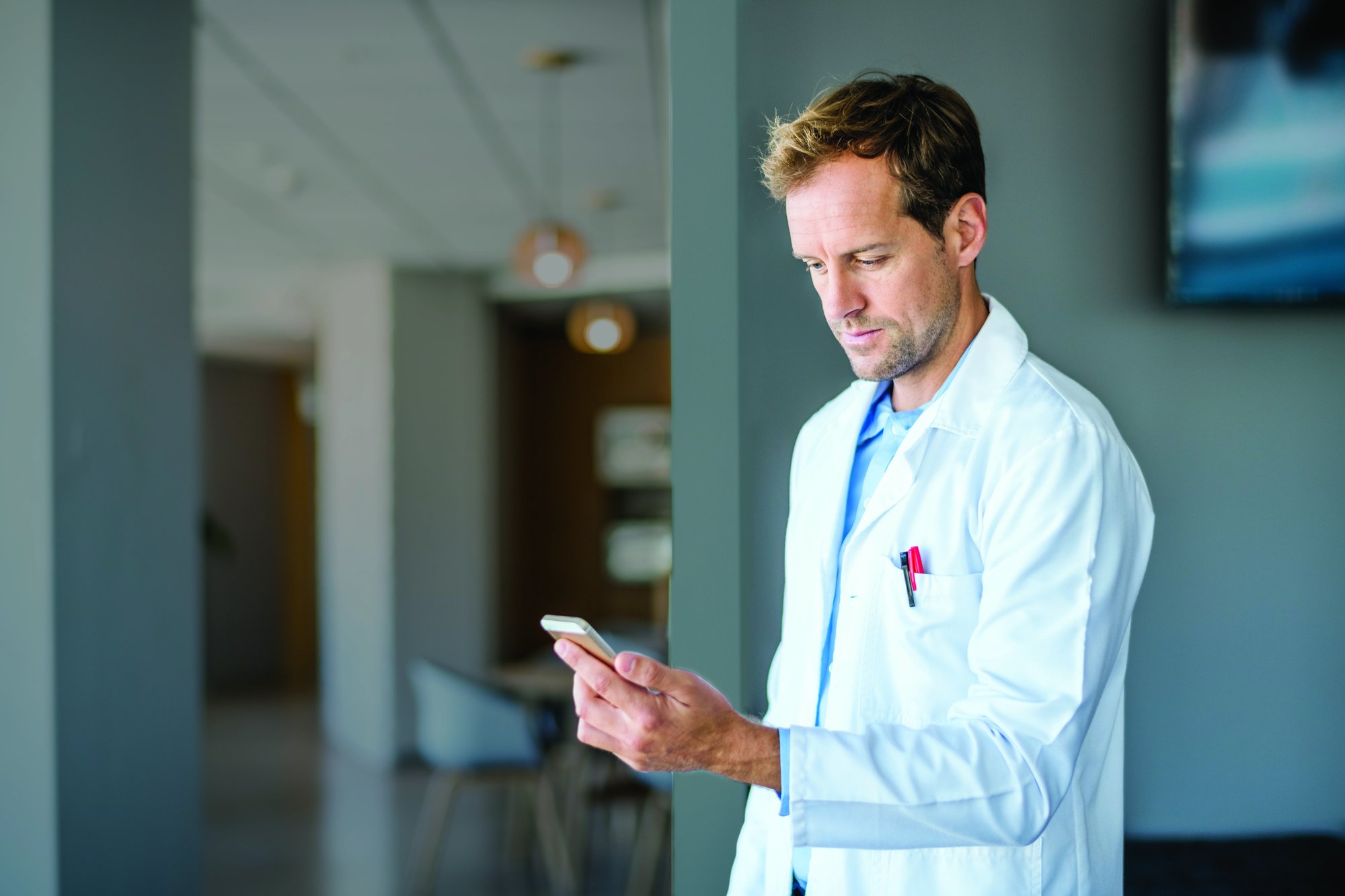 male healthcare professional looking at phone