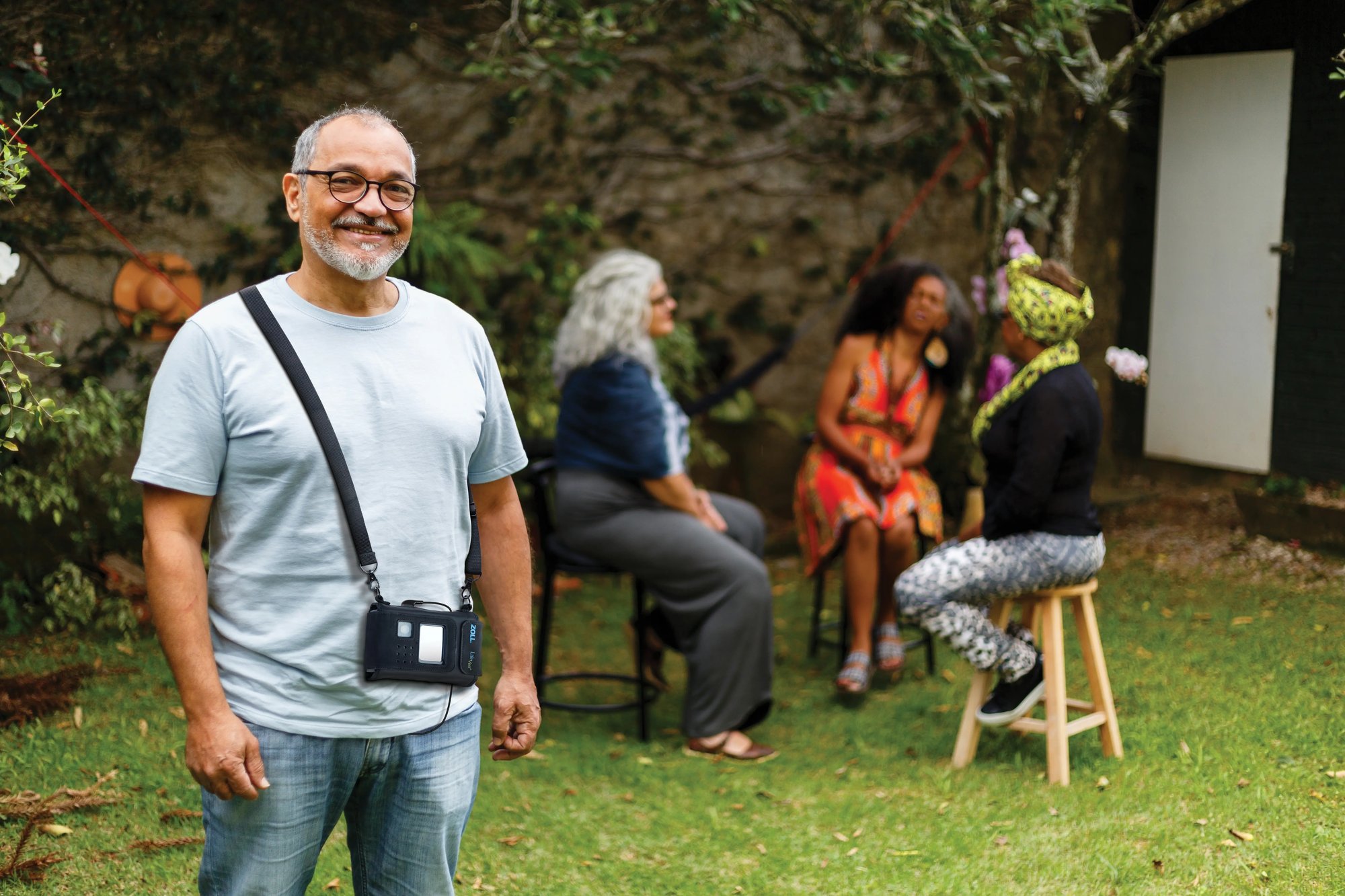 LifeVest wearable cardioverter defibrillator patient is enjoying time with friends in a backyard.