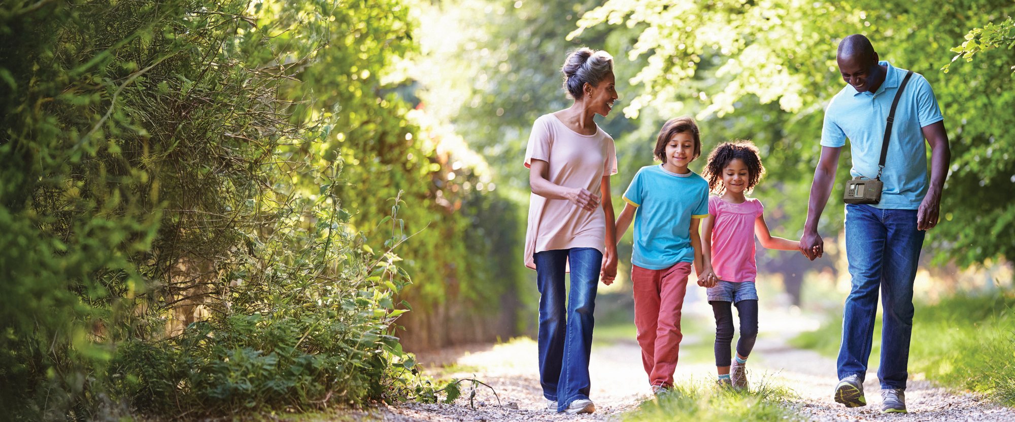 ZOLL LifeVest patient walking outdoors while holding hands with his family