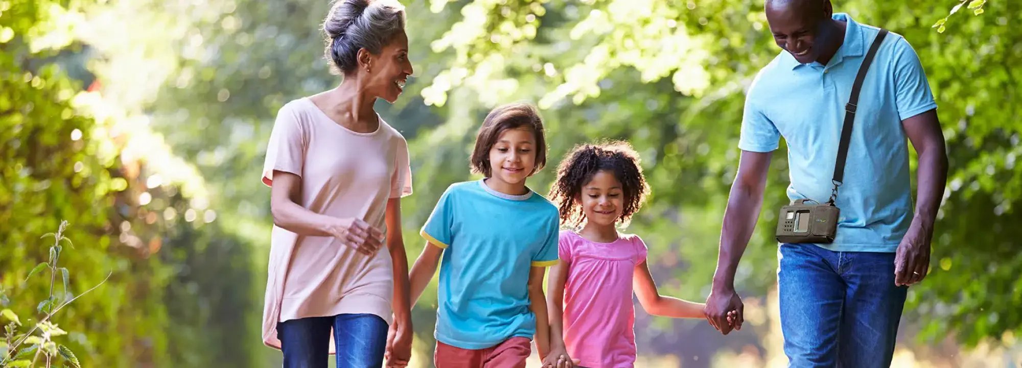 ZOLL LifeVest patient walking outdoors while holding hands with his family